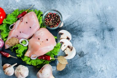 Baharat ve otlar ile kesme tahtası üzerinde çiğ tavuk fileto.