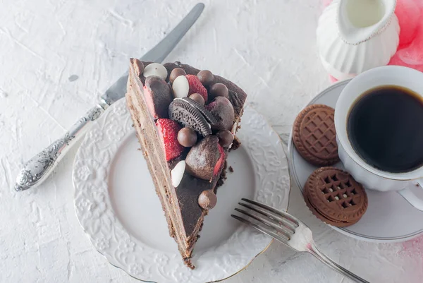 Pedaço de bolo de chocolate em um prato e uma xícara de café — Fotografia de Stock