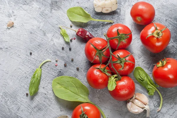 Kirschtomaten auf einem Zweig, Spinatblätter und Gewürz — Stockfoto