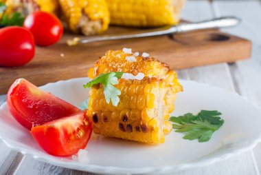 domates ve yeşillik bir tabakta mısır ızgara