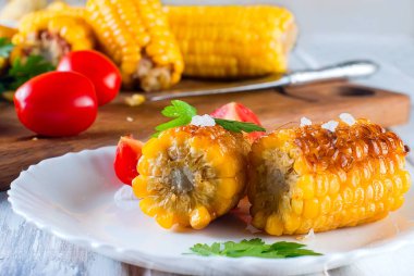 domates ve yeşillik bir tabakta mısır ızgara