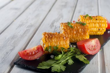 domates ve yeşillik bir tabakta mısır ızgara