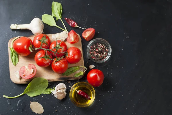 Cherry tomaten op een tak, spinazie bladeren en specerijen — Stockfoto