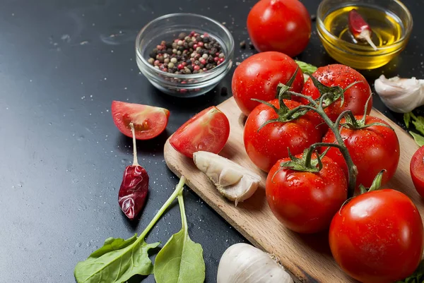 Kirschtomaten auf einem Zweig, Spinatblätter und Gewürz — Stockfoto