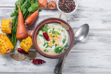 Mısır çorbası bir seramik tabak ve malzemeler