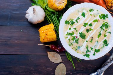 Mısır çorbası bir seramik tabak ve malzemeler