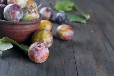 Taze Erik ile yapraklar üzerinde eski ahşap masa dağınık bahçesinden