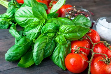 Domates ve koyu ahşap adam üzerinde taze yeşil fesleğen demet