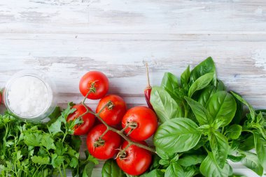 Domates ve ahşap bir zemin üzerine yeşil taze fesleğen demet,
