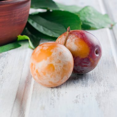 Eski ahşap masa üzerinde bir kapta bahçesinden taze Erik.