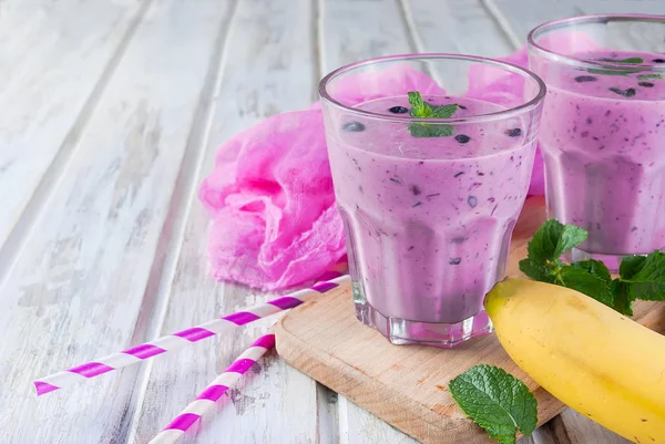 Smoothies of blueberries and banana in glasses and ingredients o — Stock Photo, Image