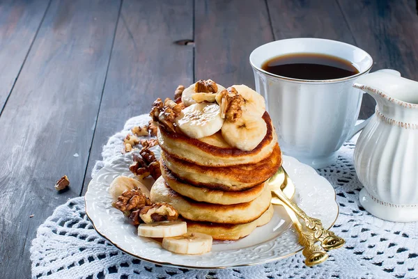 Блинчики с бананом, орехами, медом и чашкой кофе на темном бэкгро — стоковое фото
