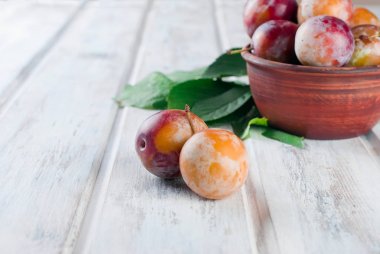 Eski ahşap masa üzerinde bir kapta bahçesinden taze Erik.