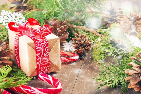 Caja de regalo atada con una cinta roja, ramas de abeto, dulces — Foto de Stock