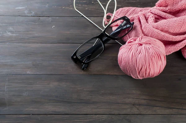 Knitting threads and glasses  on a wooden table. — Stock Photo, Image