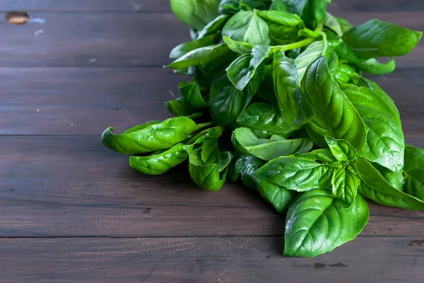 Koyu ahşap zemin üzerine yeşil taze fesleğen demet