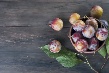 Eski ahşap masa üzerinde bir kapta bahçesinden taze Erik.