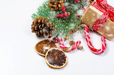 Hediye kutusu bağlı bir kırmızı kurdele, çam dalları, şeker 