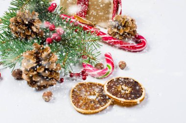 Hediye kutusu bağlı bir kırmızı kurdele, çam dalları, şeker 