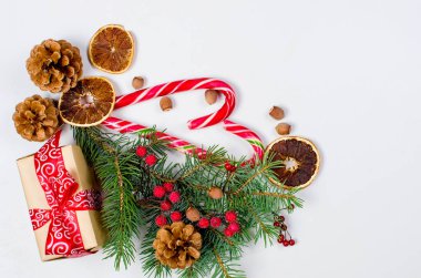 Hediye kutusu bağlı bir kırmızı kurdele, çam dalları, şeker 