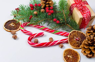 Hediye kutusu bağlı bir kırmızı kurdele, çam dalları, şeker 