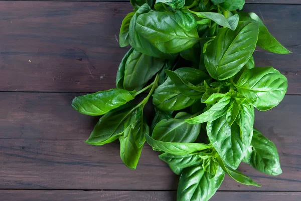 Koyu ahşap zemin üzerine yeşil taze fesleğen demet