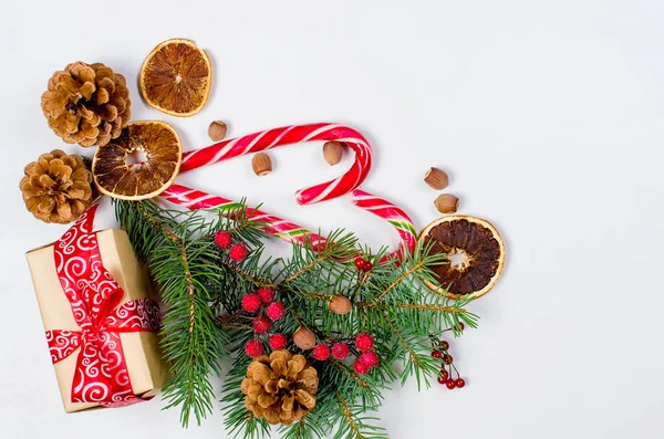 Hediye kutusu bağlı bir kırmızı kurdele, çam dalları, şeker 