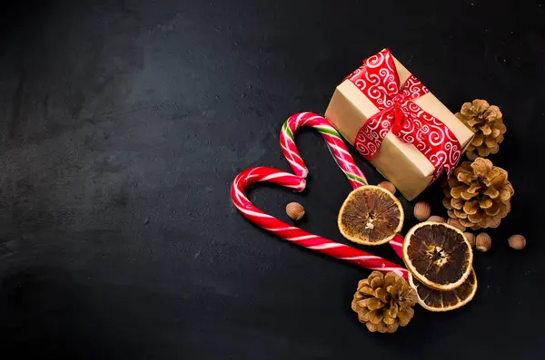 Hediye kutusu bağlı bir kırmızı kurdele, çam dalları, şeker 