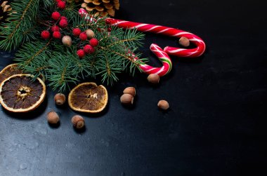 Hediye kutusu bağlı bir kırmızı kurdele, çam dalları, şeker 