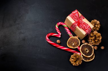 Hediye kutusu bağlı bir kırmızı kurdele, çam dalları, şeker 