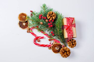 Hediye kutusu bağlı bir kırmızı kurdele, çam dalları, şeker 