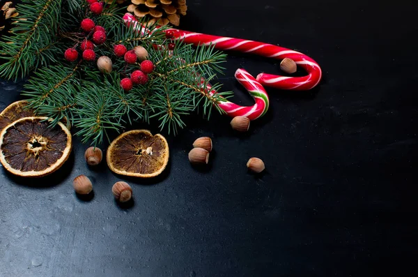 Caixa de presente amarrada com uma fita vermelha, ramos de abeto, doces — Fotografia de Stock