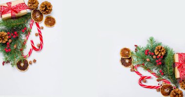 Hediye kutusu bağlı bir kırmızı kurdele, çam dalları, şeker 