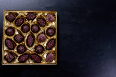 Koyu arkaplanda bir kutuda çikolata şekeri