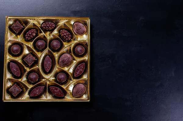 Koyu arkaplanda bir kutuda çikolata şekeri