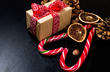 Kırmızı kurdele, siyah arka plan üzerine şeker ile bağlı hediye kutusu