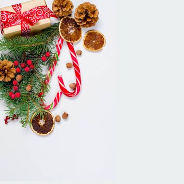 Hediye kutusu bağlı bir kırmızı kurdele, çam dalları, şeker 