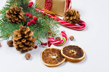 Hediye kutusu bağlı bir kırmızı kurdele, çam dalları, şeker 