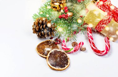 Hediye kutusu bağlı bir kırmızı kurdele, çam dalları, şeker 