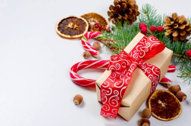Hediye kutusu bağlı bir kırmızı kurdele, çam dalları, şeker 