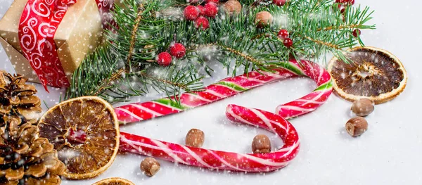 Coffret cadeau attaché avec un ruban rouge, branches de sapin, bonbons — Photo