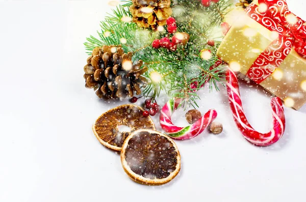 Hediye kutusu bağlı bir kırmızı kurdele, çam dalları, şeker 