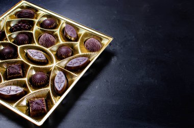 Koyu arkaplanda bir kutuda çikolata şekeri