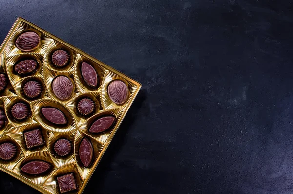 Koyu arkaplanda bir kutuda çikolata şekeri