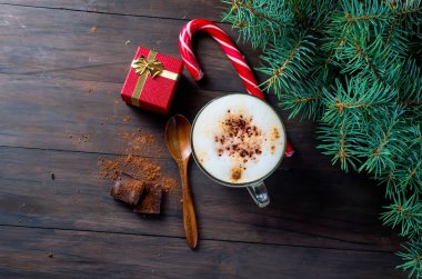 Fincan sıcak kahve latte, tarçın, kurabiye ve köknar dalı ve 