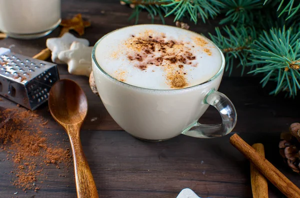 Fincan sıcak kahve latte, tarçın, kurabiye ve çam dalları. 