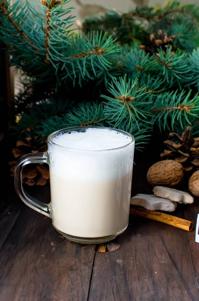 Fincan sıcak kahve latte, tarçın, kurabiye ve çam dalları. 