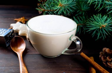 Fincan sıcak kahve latte, tarçın, kurabiye ve çam dalları. 