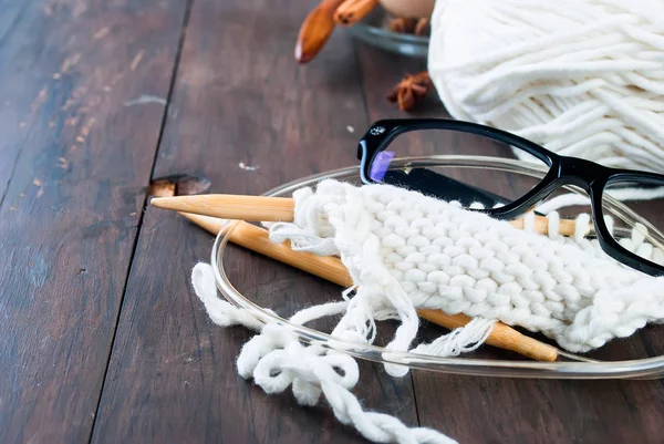 Cup of tea with milk , knitting threads and glasses  on a wooden — Stock Photo, Image