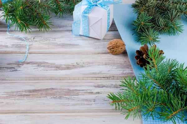 Caixa de presente amarrada com uma fita azul, ramos de abeto, cones de pinheiro — Fotografia de Stock